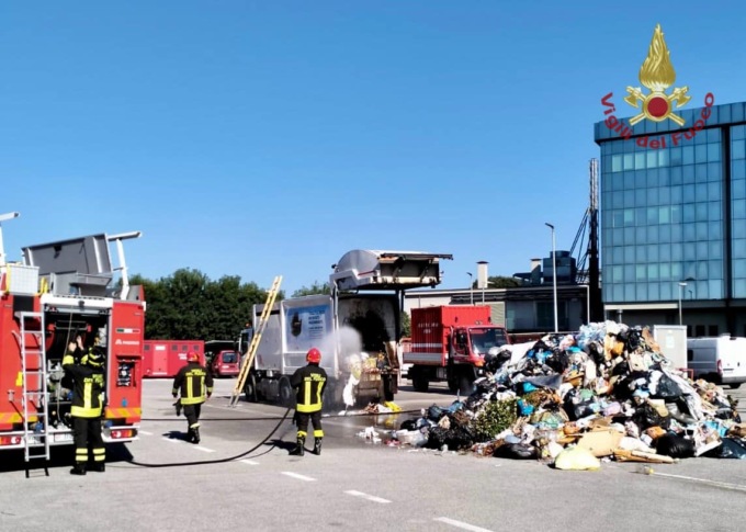 Nota delle fiamme provenire dal carico rifiuti e si reca immediatamente dai Vigili del fuoco